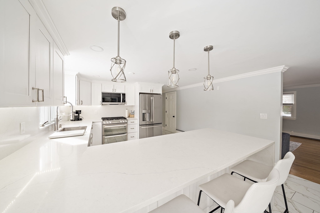 10 Dowd Avenue Wareham, MA 02571 - Photo 5 of 42 a kitchen with stainless steel appliances kitchen island granite countertop a refrigerator a stove and white cabinets with wooden floor