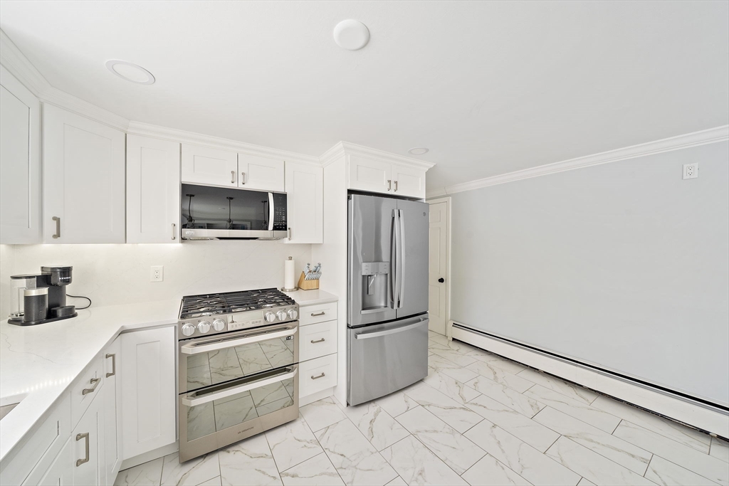 10 Dowd Avenue Wareham, MA 02571 - Photo 9 of 42 a kitchen with white cabinets and stainless steel appliances