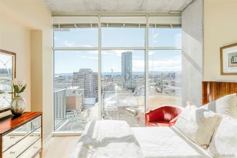 a bedroom with furniture and a large window