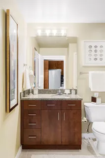 a bathroom with a granite countertop sink a mirror and a toilet