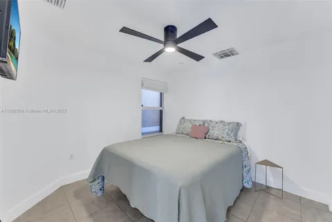 a bedroom with a bed and a ceiling fan