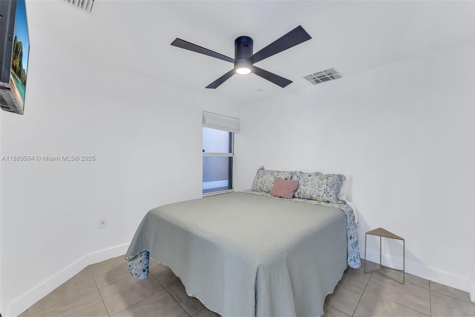 21059 Southwest 90th Place Cutler Bay, FL 33189 - Photo 15 of 20 a bedroom with a bed and a ceiling fan