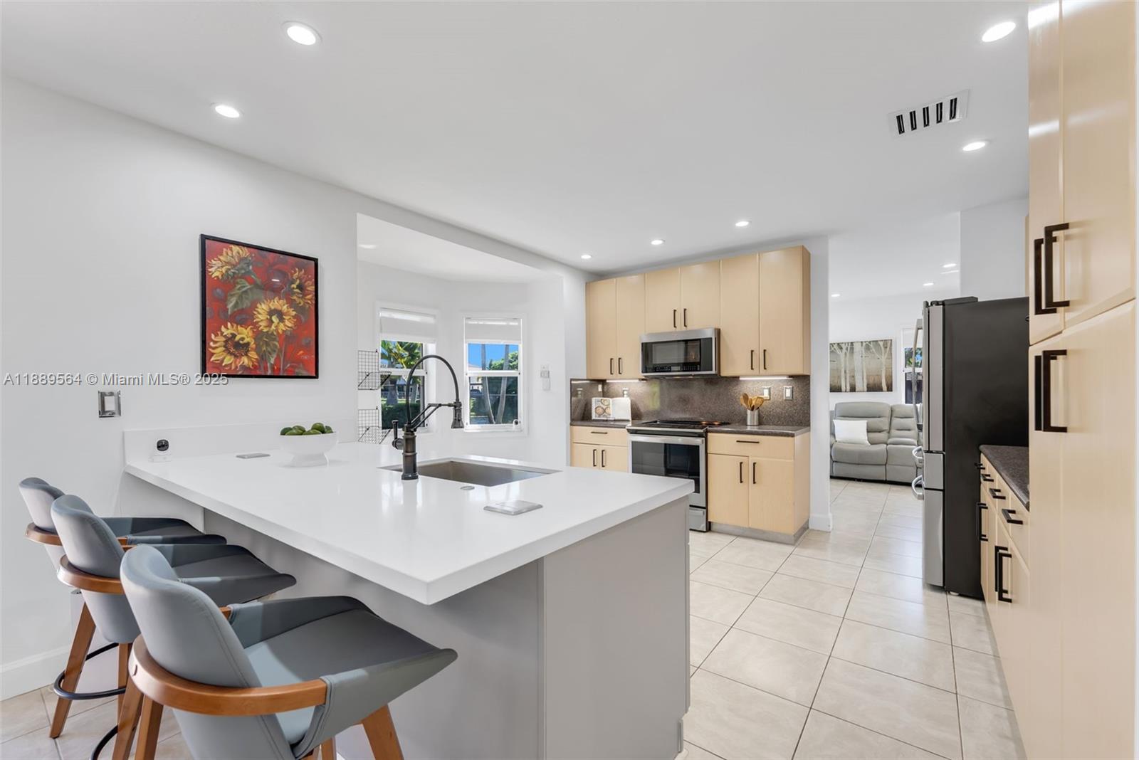 21059 Southwest 90th Place Cutler Bay, FL 33189 - Photo 5 of 20 a kitchen with a refrigerator a stove a sink a dining table and chairs