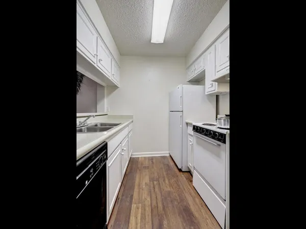 a kitchen with granite countertop a stove top oven and sink