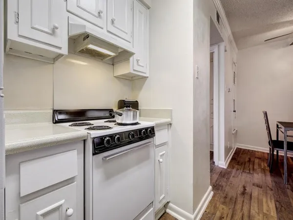 a white stove top oven sitting inside of a kitchen