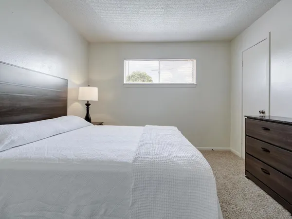 a bedroom with a bed and a night stand