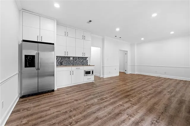 a kitchen with stainless steel appliances granite countertop a refrigerator and a stove top oven
