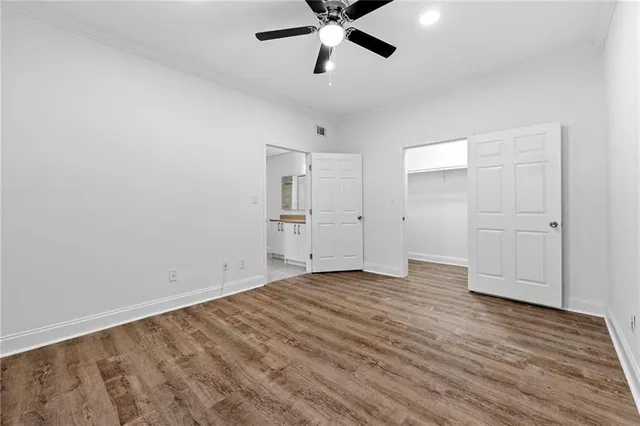a view of empty room with wooden floor and ceiling fan