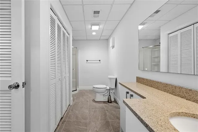 a spacious bathroom with a granite countertop sink a toilet and a shower