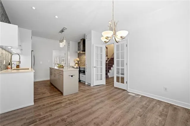 a view of a kitchen with refrigerator and wooden floor
