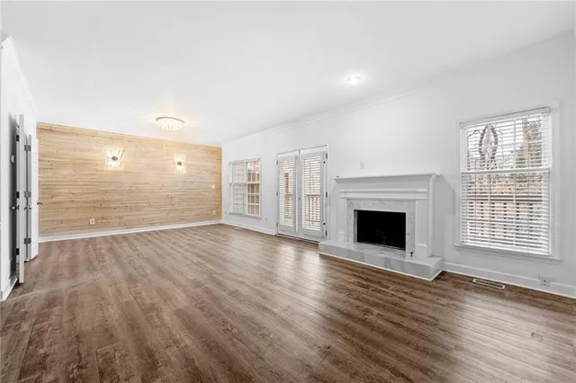 a view of empty room with wooden floor and fireplace