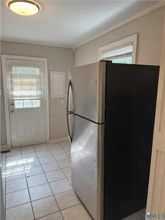 a view of a refrigerator in kitchen and a window in a room