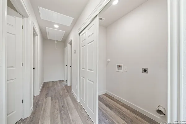 a view of a hallway with wooden floor and staircase