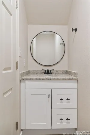 a bathroom with a granite countertop mirror and a sink
