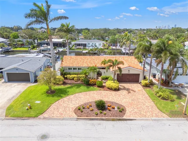 a view of a house with a yard and potted plants