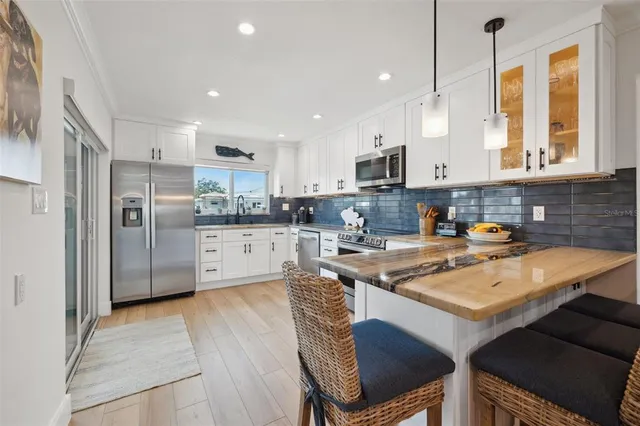 a kitchen with stainless steel appliances granite countertop a stove and a wooden floors