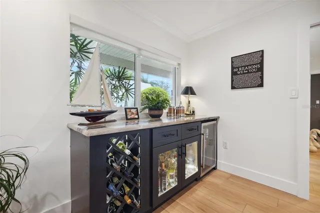 a living room with stainless steel appliances furniture a rug kitchen view and a chandelier