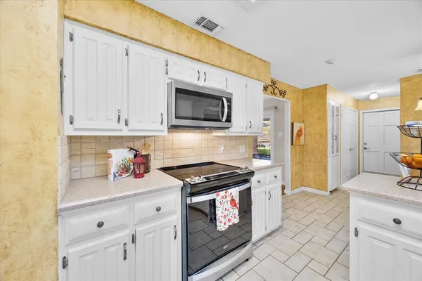 a kitchen with stainless steel appliances white cabinets and stove