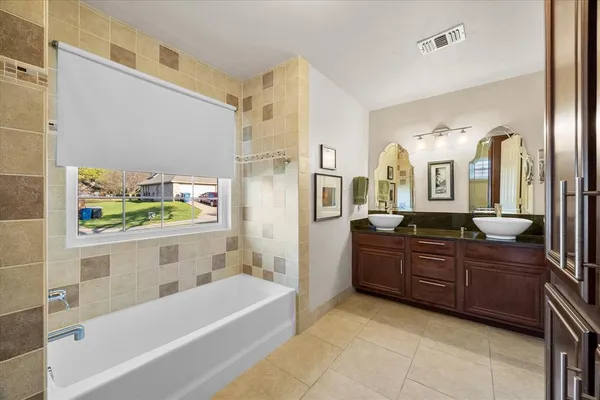 a bathroom with a tub sink and mirror
