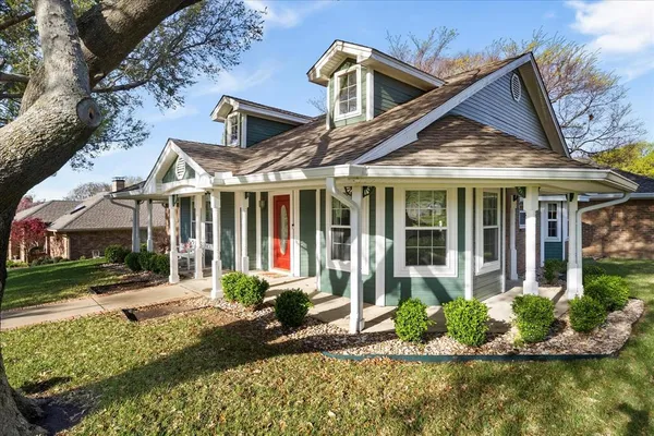 a front view of a house with a yard and potted plants
