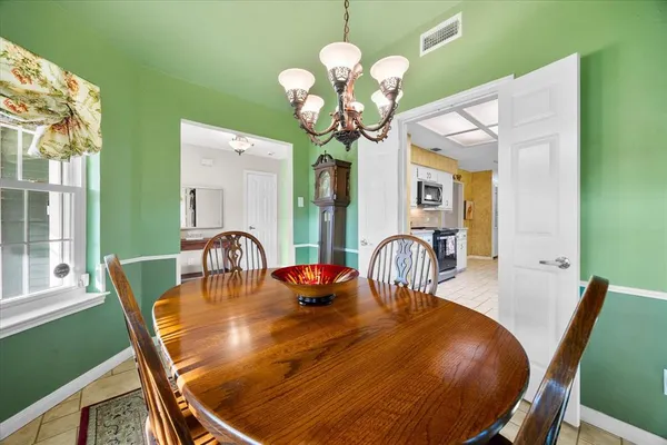a dining room filled chandelier and wooden floor
