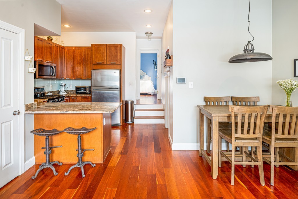 295 D Street, Unit 1 Boston, MA 02127 - Photo 3 of 13 a kitchen with stainless steel appliances granite countertop a refrigerator a stove and a wooden floors