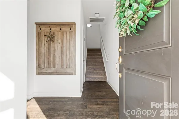 a view of a hallway with wooden floor and a potted plant