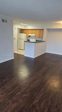 a view of a room with wooden floor and a window