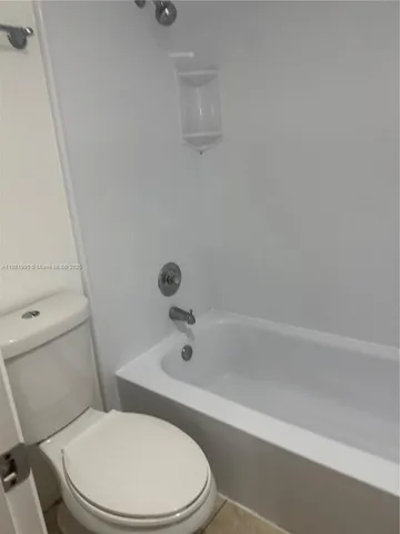 a white toilet and tub sitting next to a bathroom sink