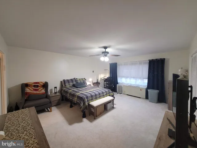 a spacious bedroom with a bed furniture and a flat screen tv