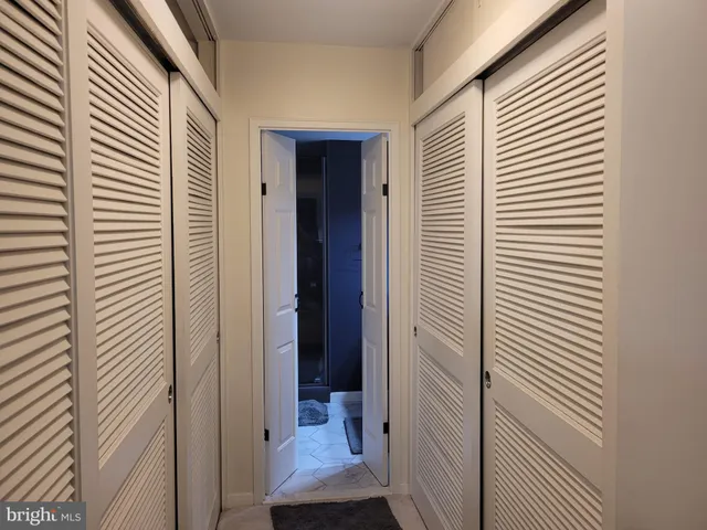 a view of a hallway with a door and chair