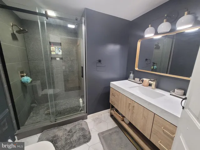 a bathroom with a sink mirror and shower