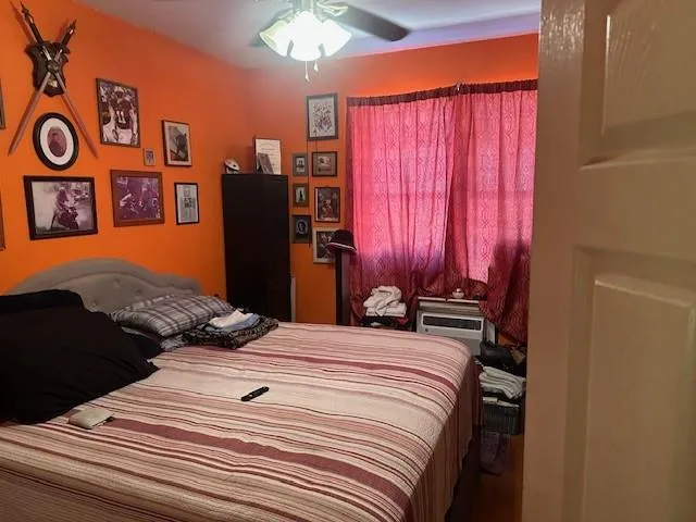 a bedroom with a bed and a lamp on dresser