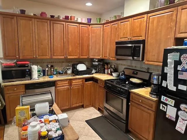 a kitchen with stainless steel appliances a stove a sink and a microwave