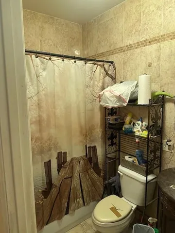 a bathroom with a toilet and a shower curtain