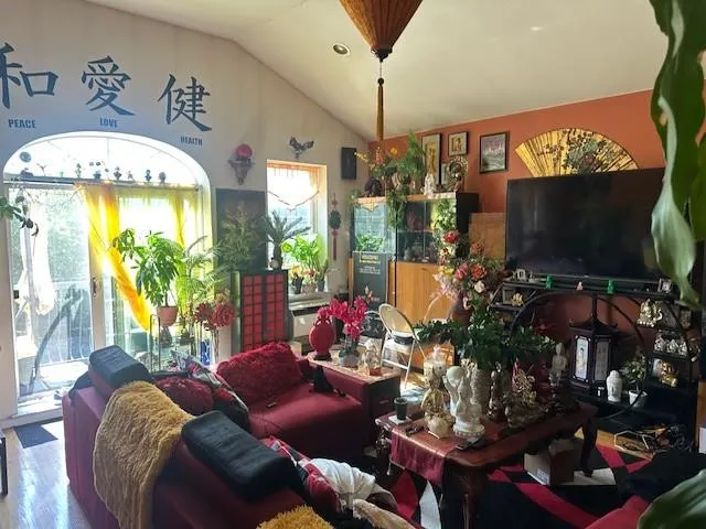 a living room with furniture a flat screen tv and a floor to ceiling window