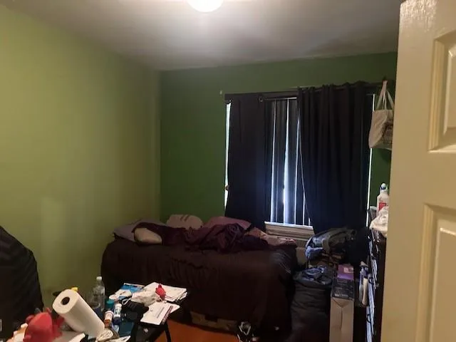 a bed sitting in a bedroom next to a window and storage