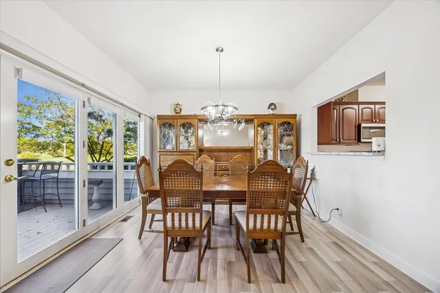 a dining room with furniture a chandelier and wooden floor