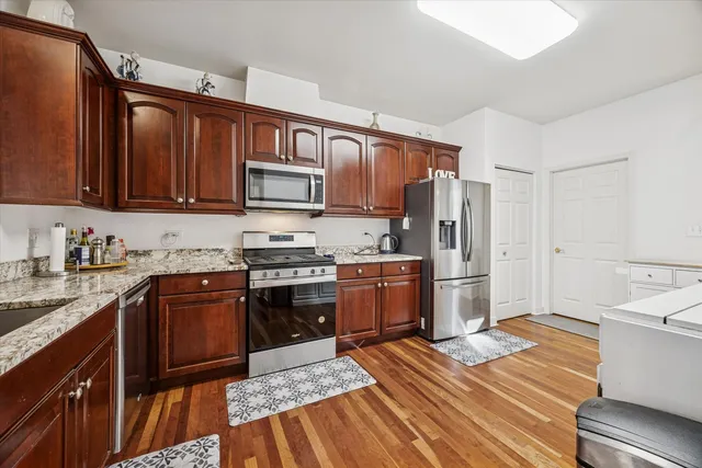 a kitchen with stainless steel appliances granite countertop a refrigerator stove and sink