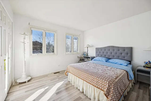 a bedroom with a bed and wooden floor