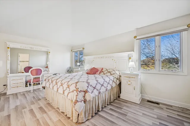 a bedroom with a bed and a large window