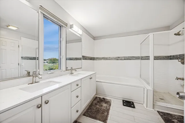 a bathroom with a granite countertop sink a mirror and shower