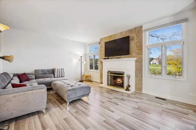 a living room with furniture a flat screen tv and a fireplace