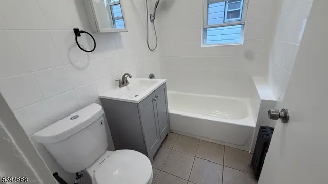a bathroom with a granite countertop toilet a sink and a bathtub