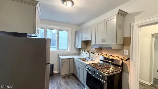 a kitchen with stainless steel appliances granite countertop a stove a sink dishwasher and a refrigerator