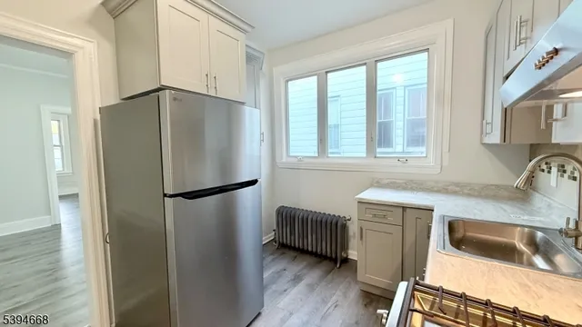 a kitchen with granite countertop a refrigerator and a sink