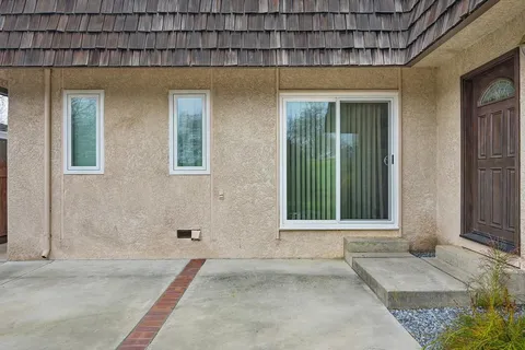 a view of a house with backyard sitting area and garden
