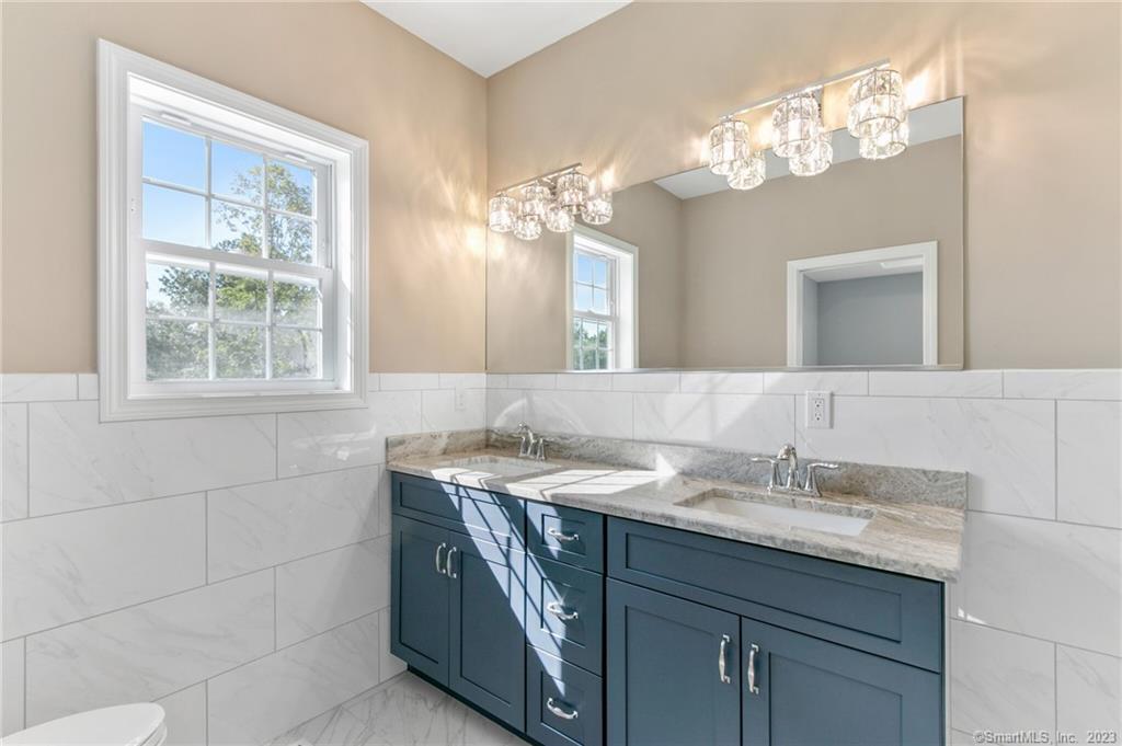 18 A Talcott Ridge Drive Middletown, CT 06457 - Photo 25 of 32 a bathroom with a granite countertop sink a large mirror and a vanity