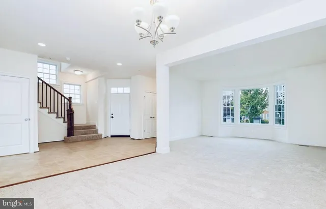 an empty room with windows and ceiling fan