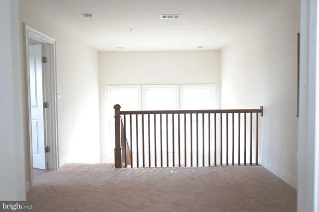 a view of staircase with lots of frames on wall and a window